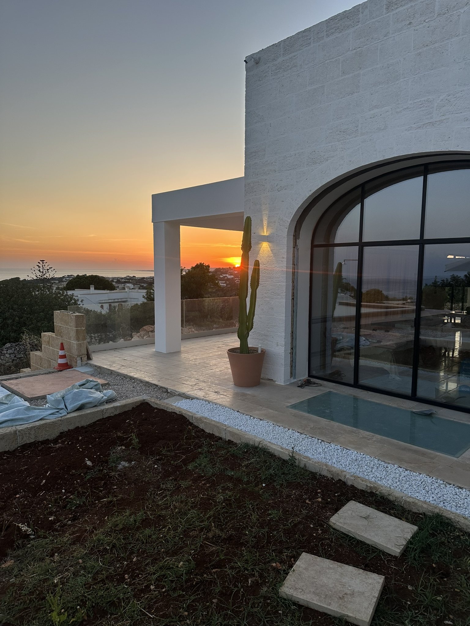 Villa en pierre avec arche vitrée au coucher du soleil